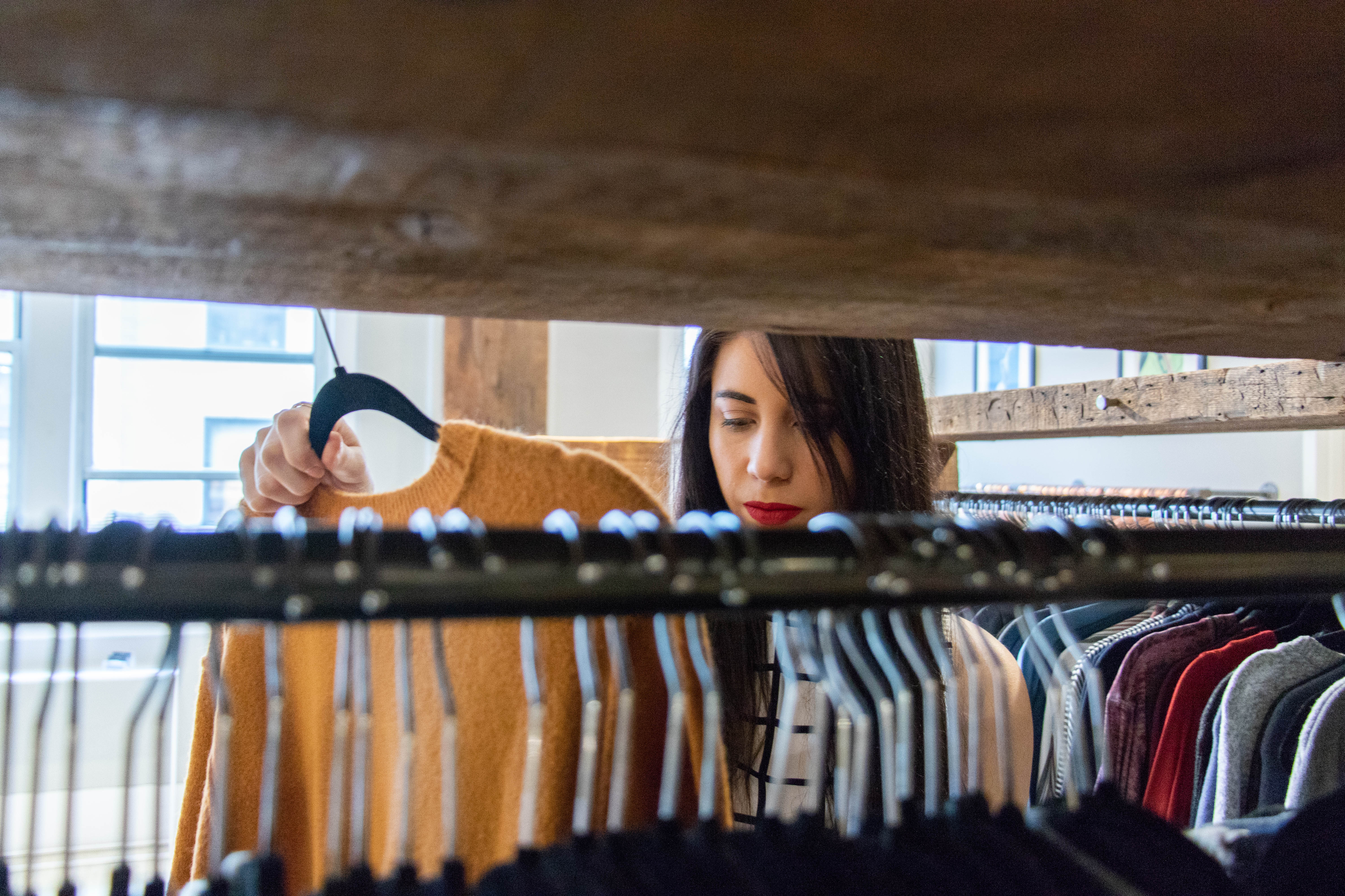 Student looking through a clothing rack.