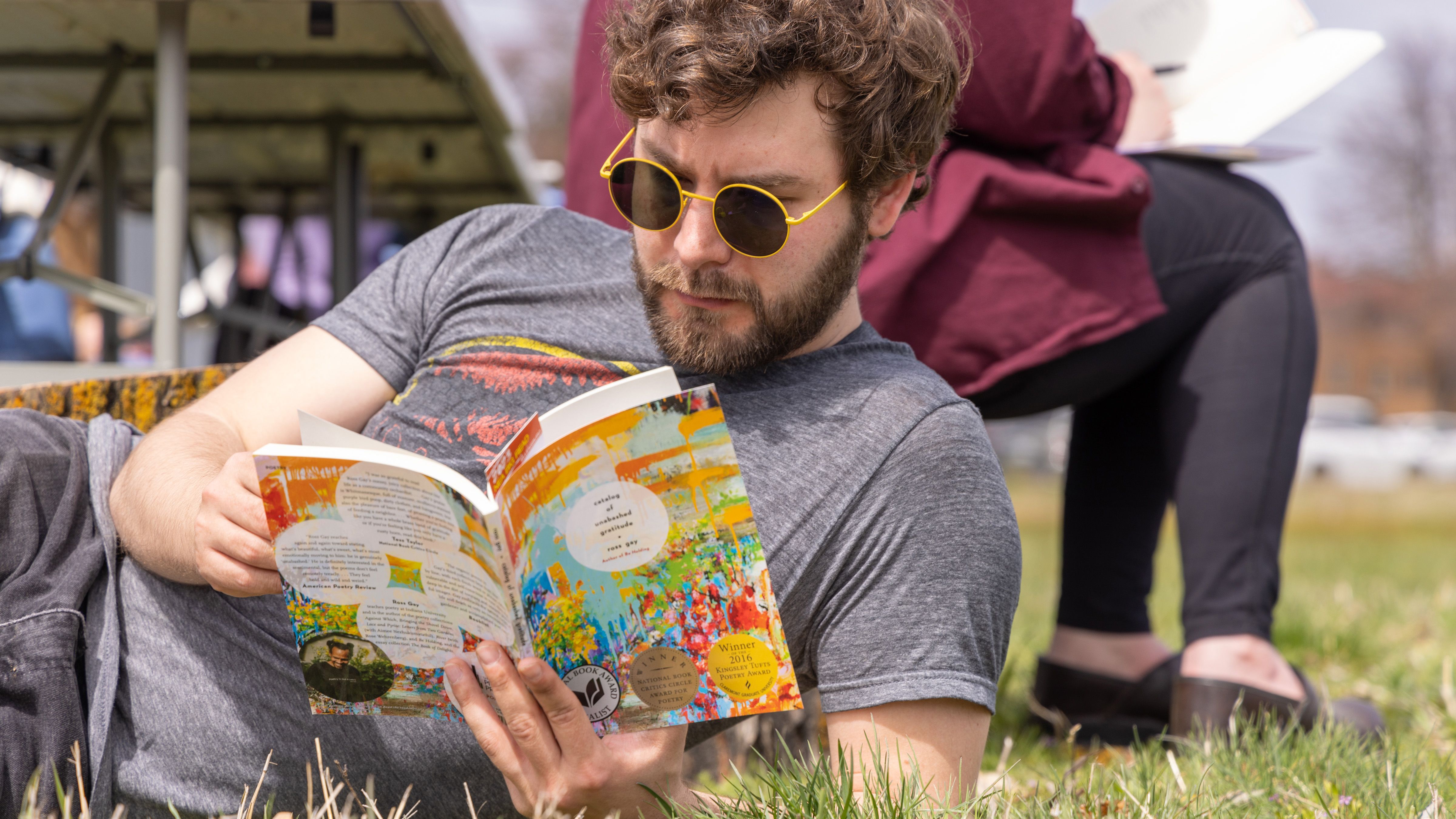 Student reading in the grass. 