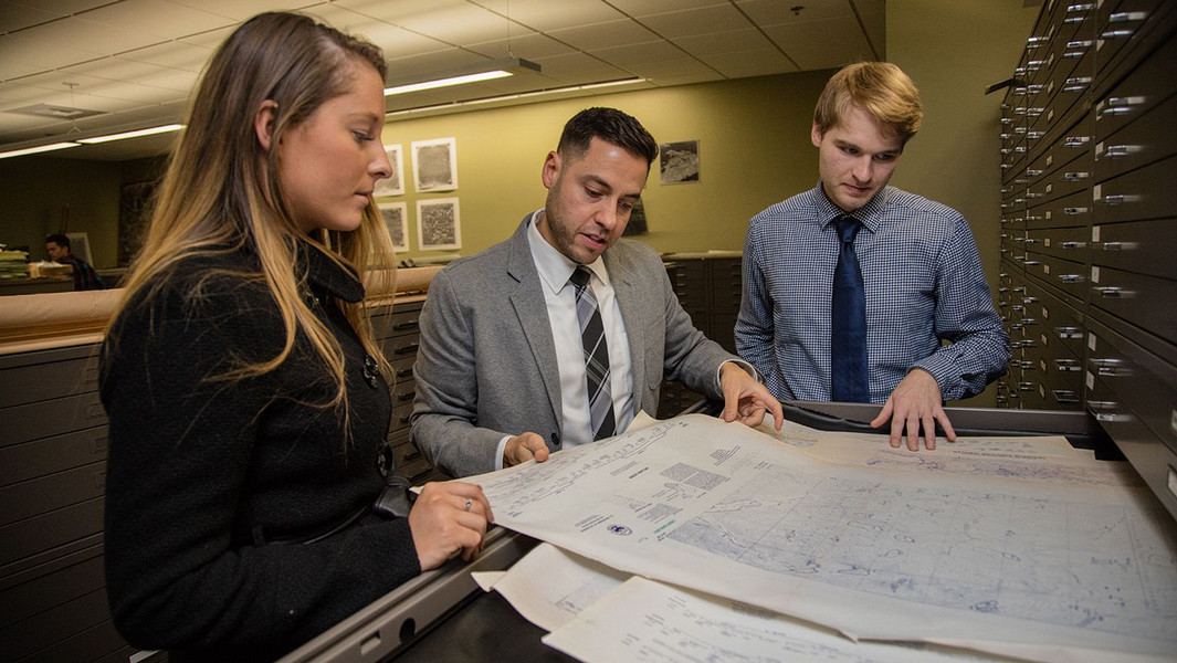 Three members of the geography department within Central Washington University look at a map and seek directions.