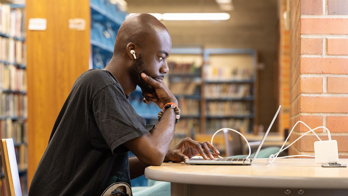 A student studies intensively within the library. 