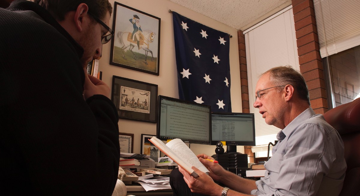 Two history professors viewing a book in an office at CWU.