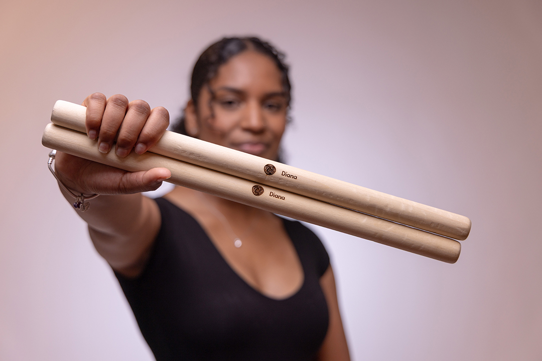 Diana Schneider holds up a pair of drumsticks