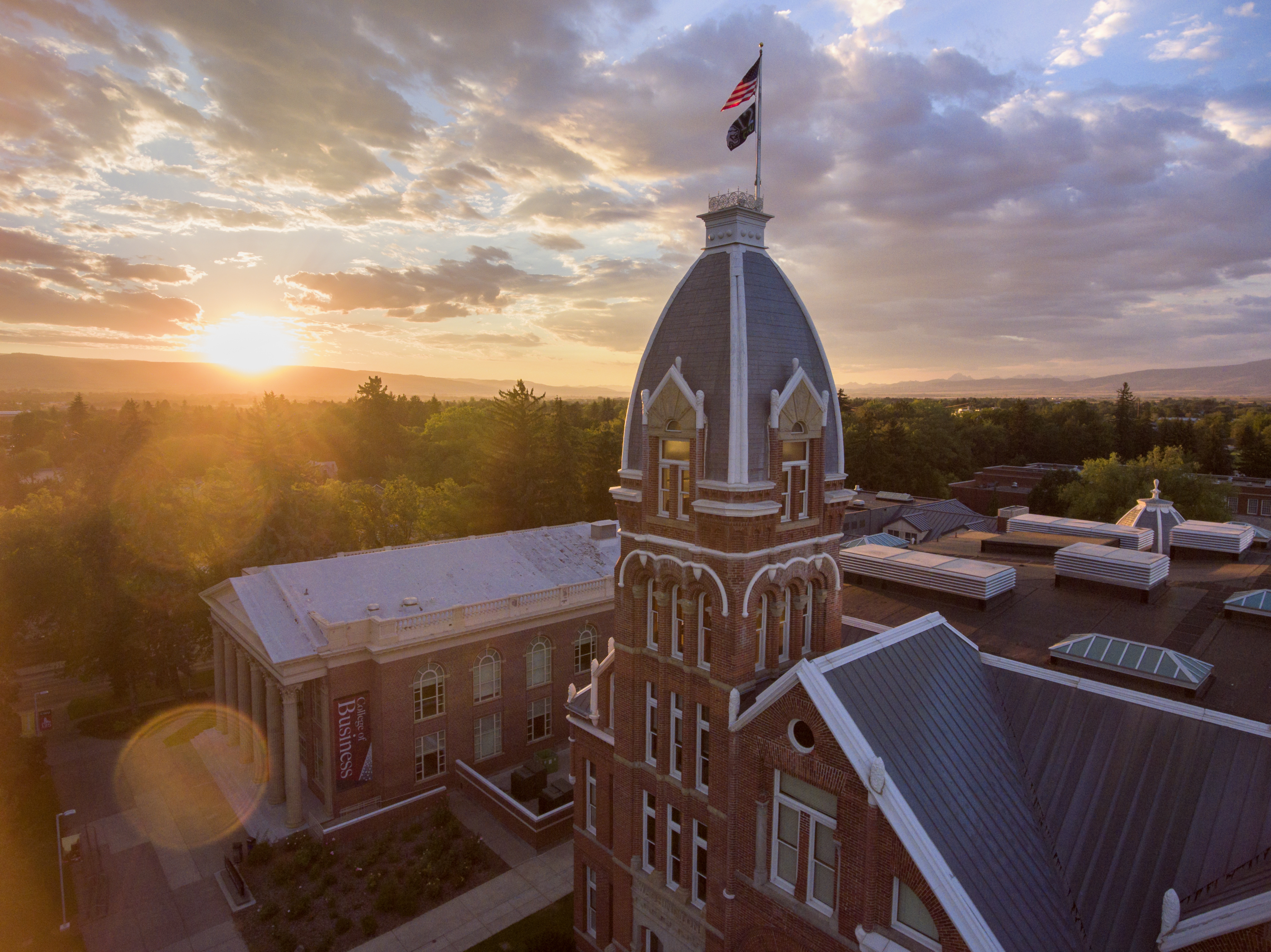 Barge hall in the summer with the sun setting in the background.