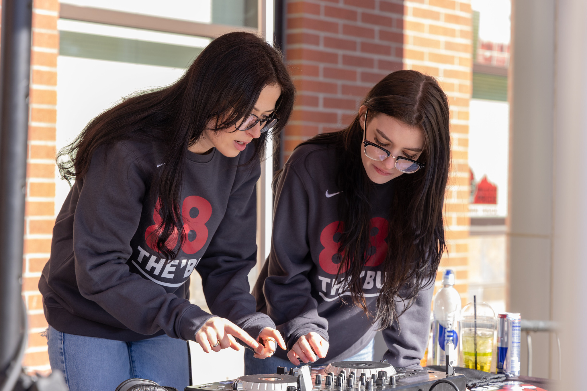 two girls adjusting audio equipment