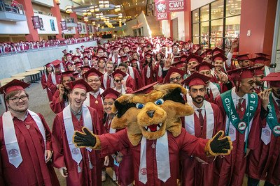 Wellington Wildcat posing with CWU graduates in the SURC