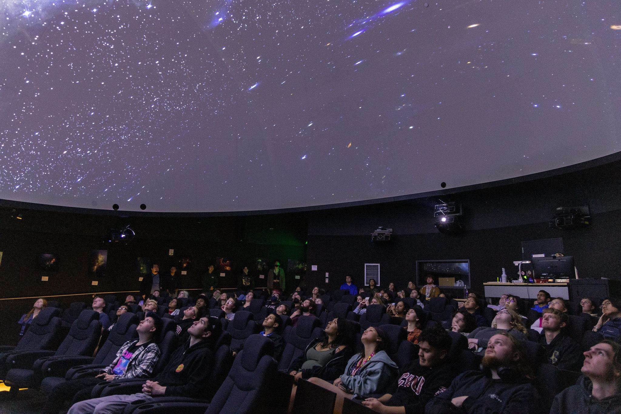 Students in observatory looking up at the stars