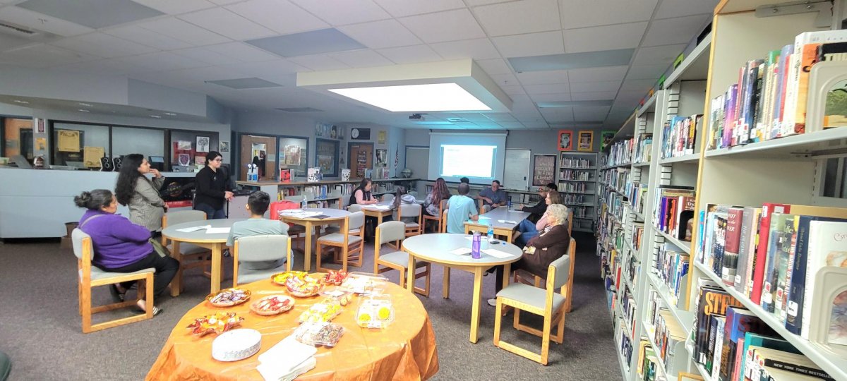 Several students sitting around circular tables in a class room.