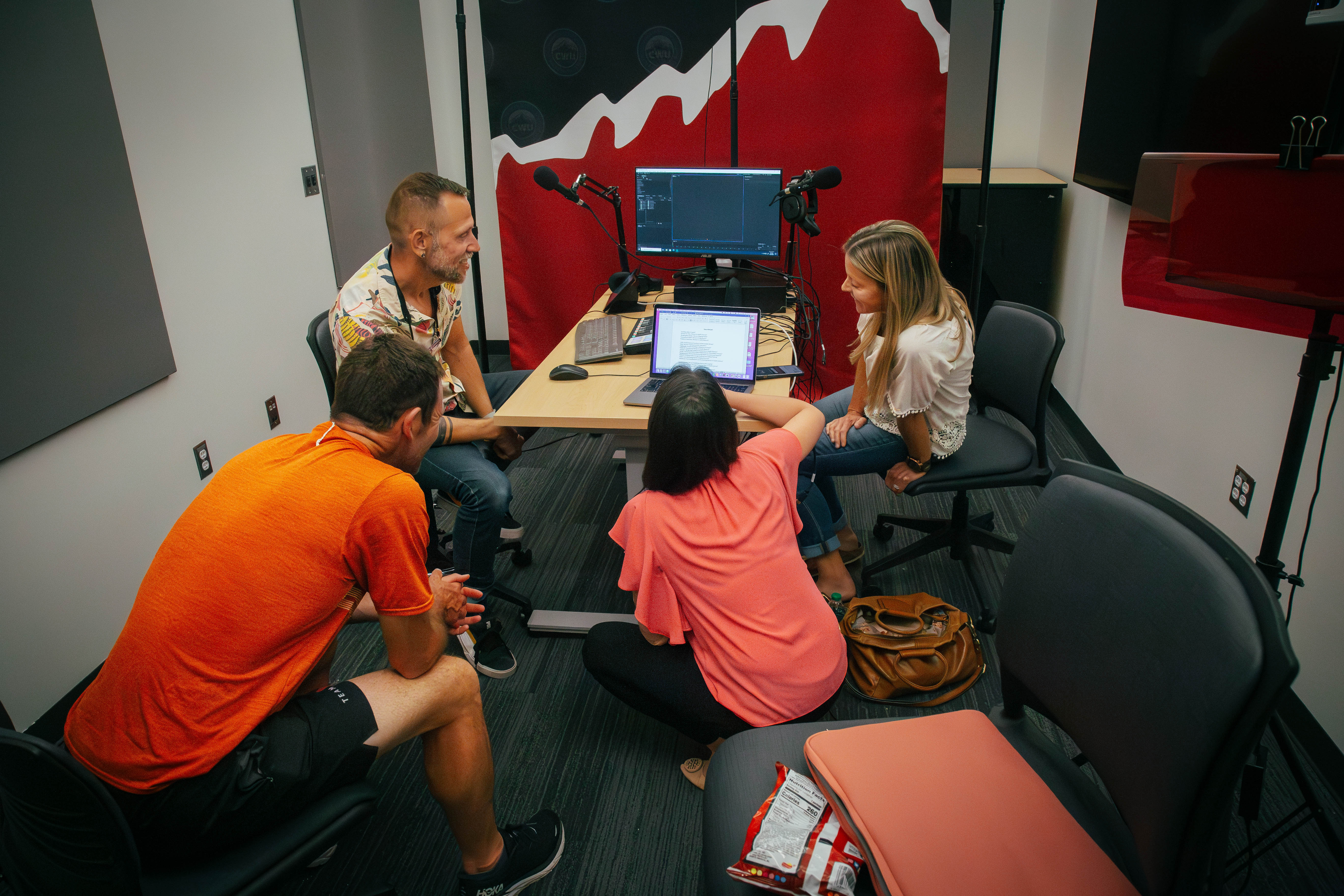People engaged in a conversation about podcasting and using the MEC equipment to create one