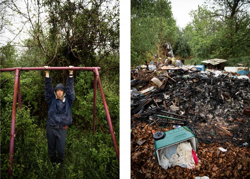 A person hanging from a swing set missing the swing seat and  overgrown with plants. The other is a pile of trash in the woods. 