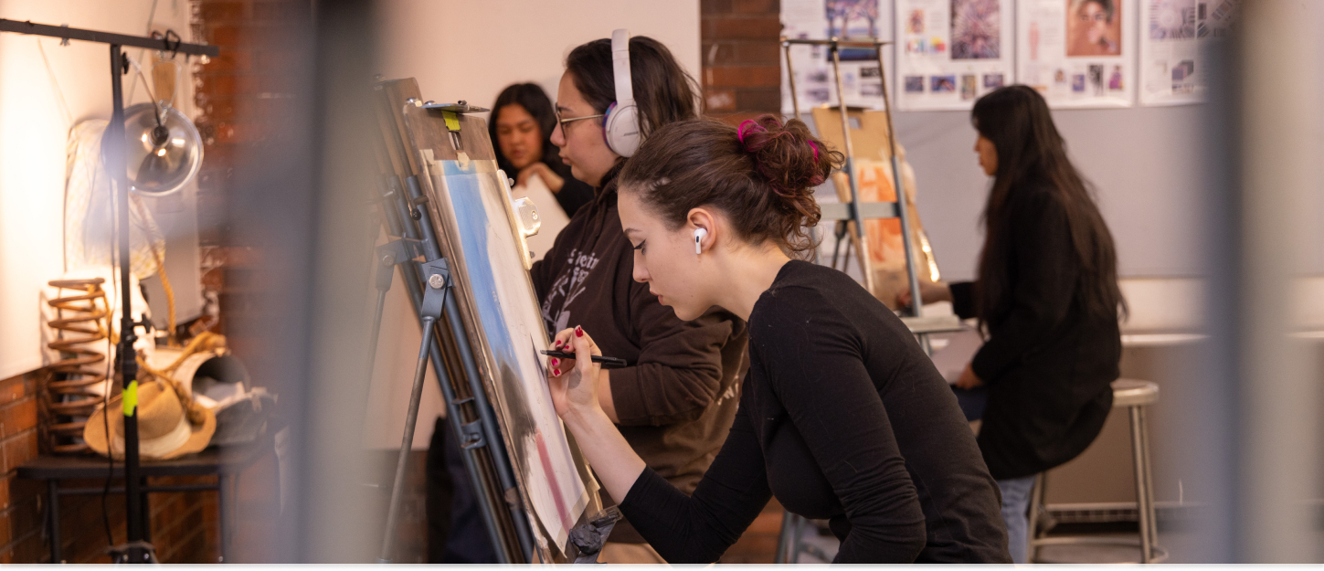 Students painting and listening to music during class. 