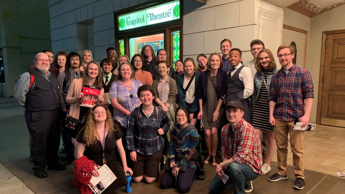 Group of CWU students kneeling and posing in front of a theatre in Yakima.