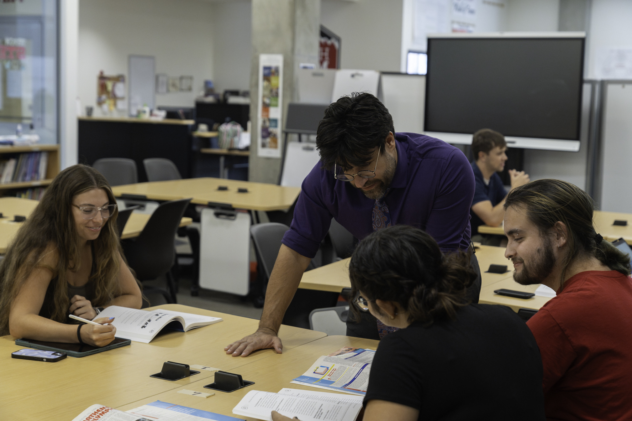 Students working with a professor on a project.