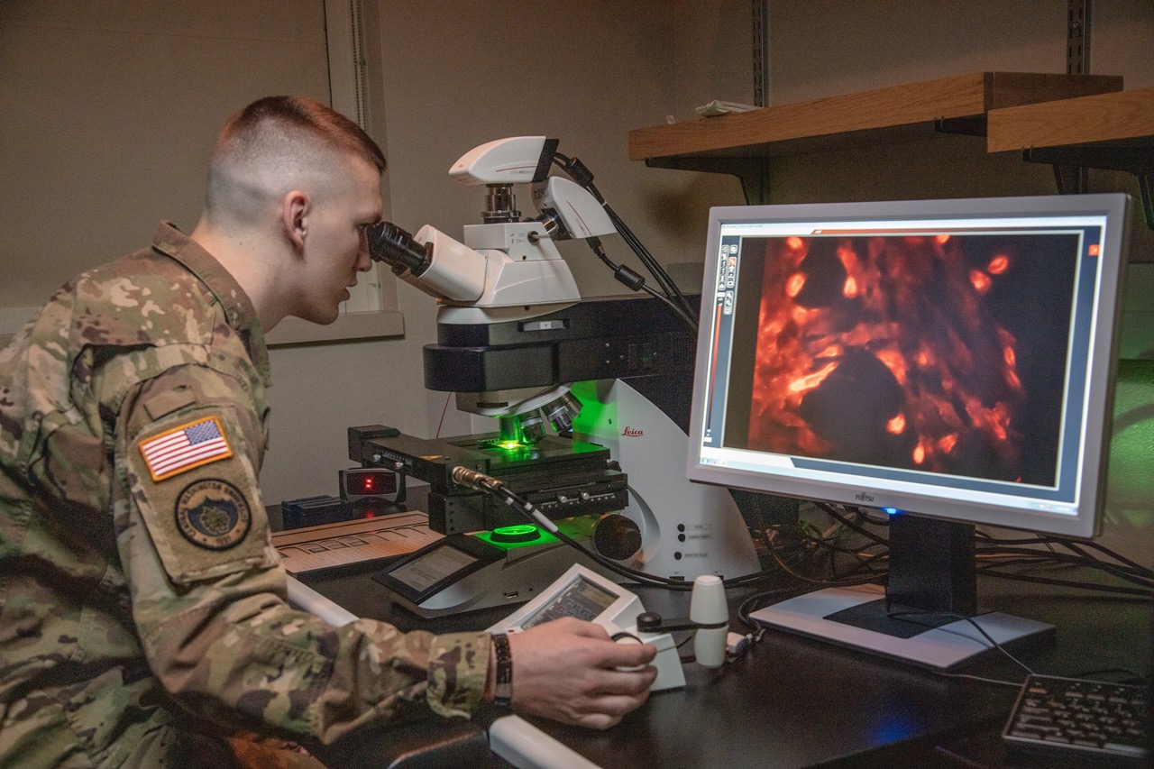 ROTC student looking into a microscope