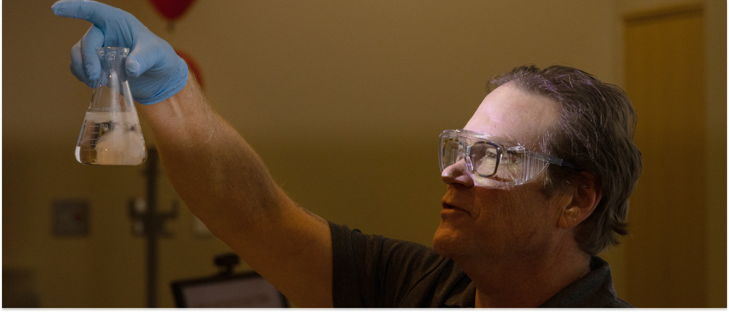Professor holding up a beaker in front of the class