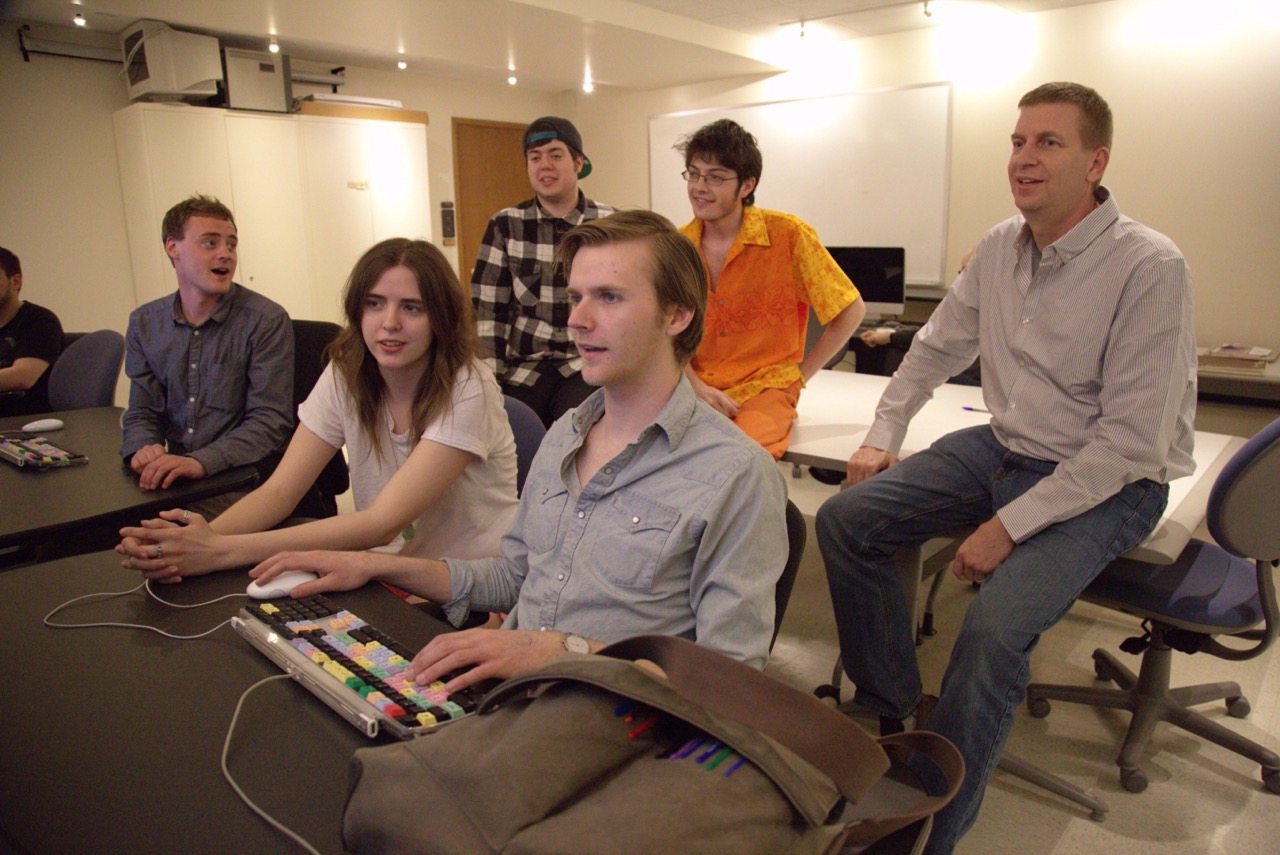 Students working with faculty behind a computer