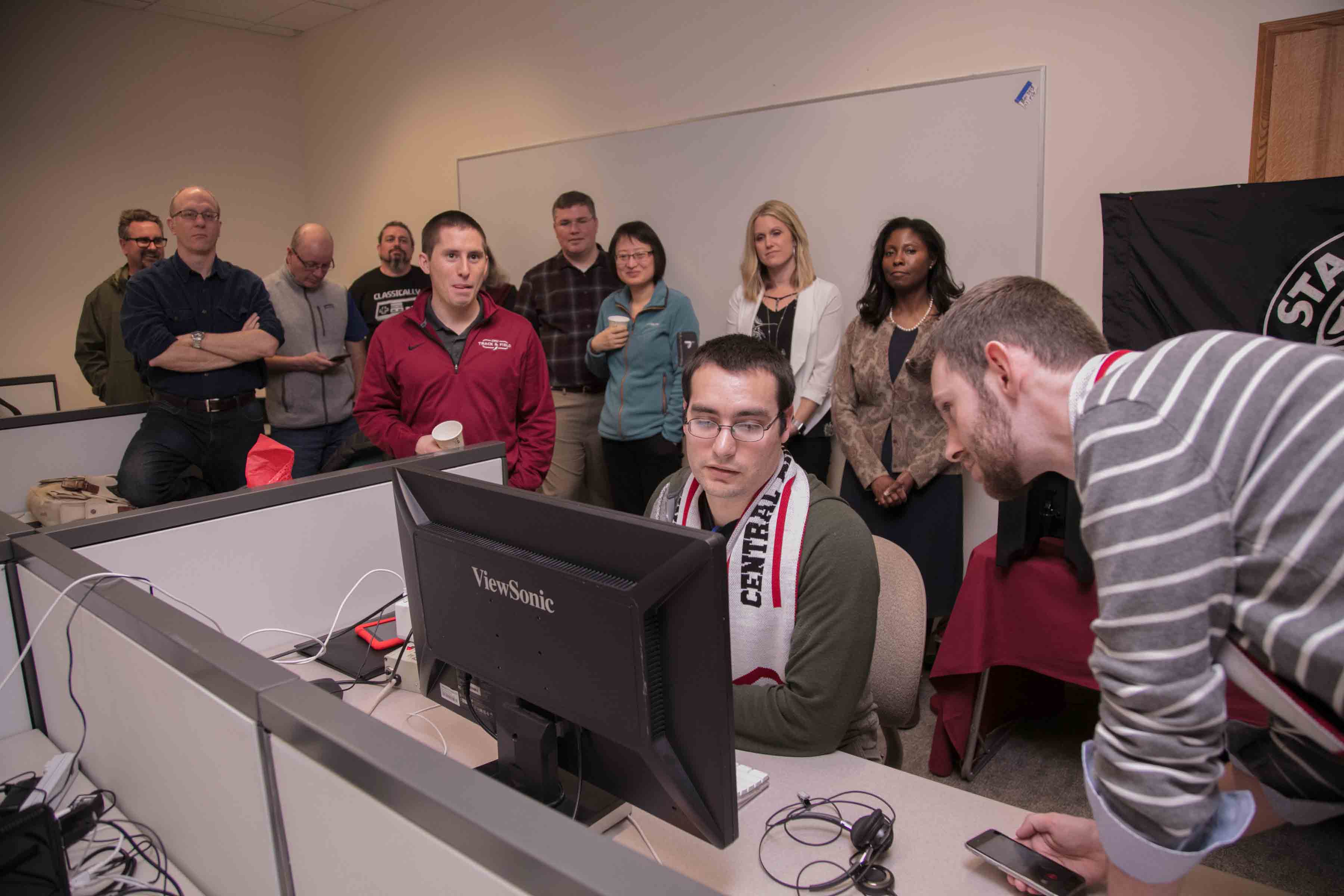 Group of students all standing around a computer