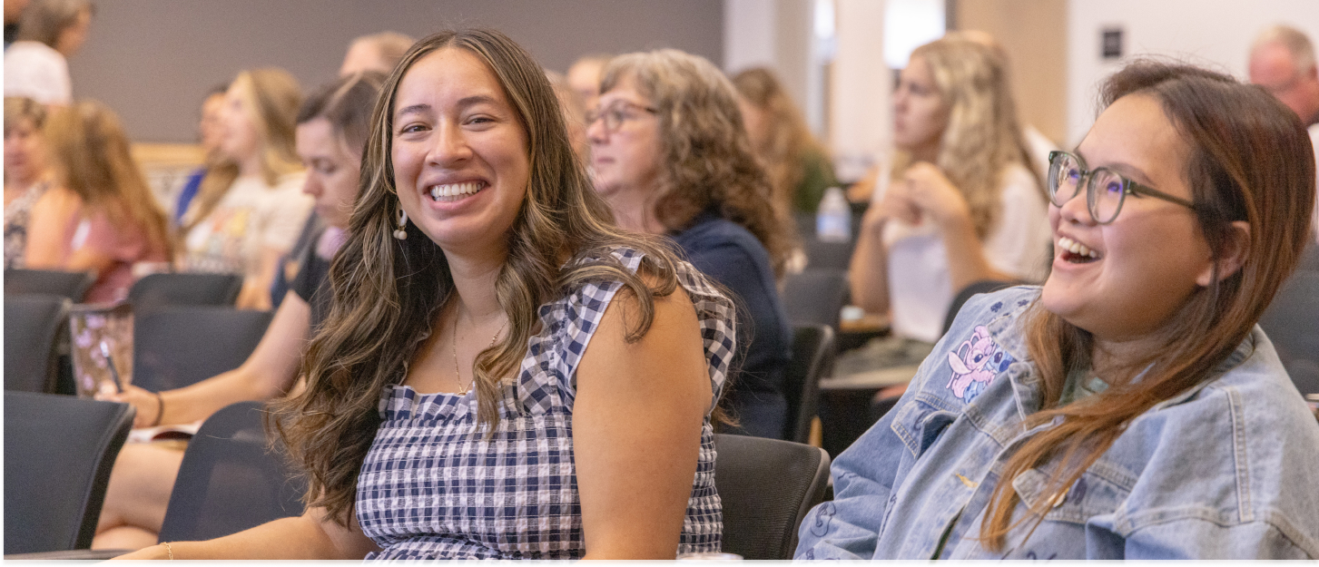 Two teachers laughing during a presentation