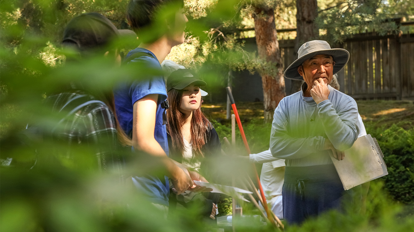 Students and professor standing in the Japanese garden