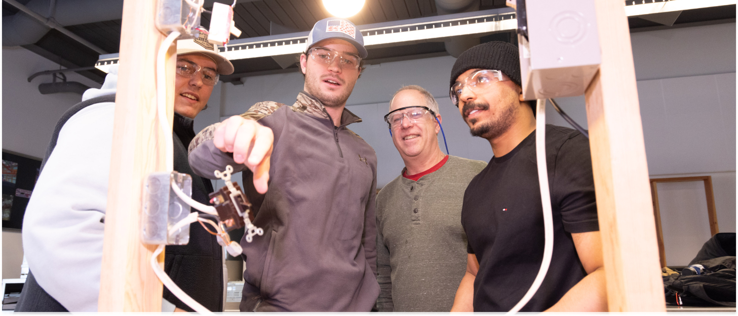 Four students wroking on a construction project with a lightbulb
