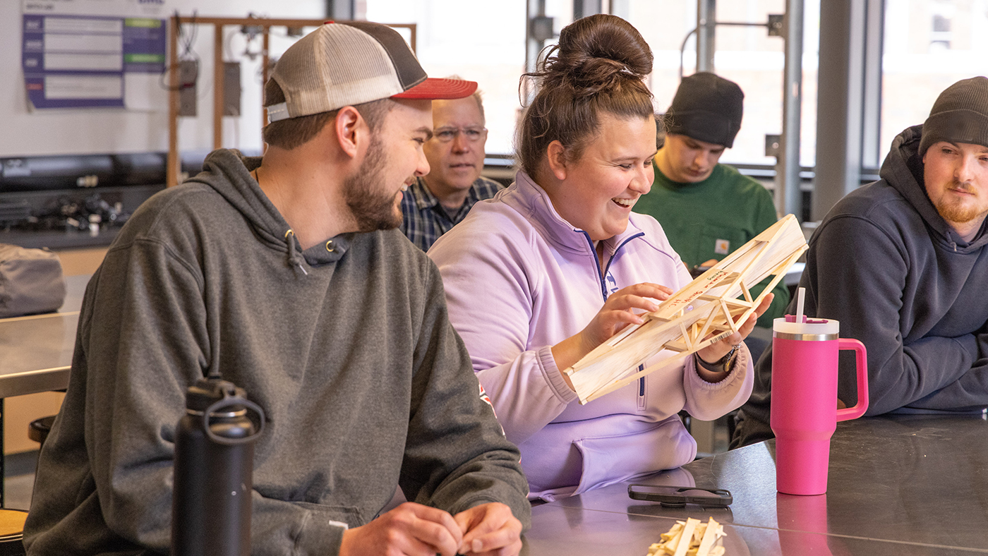 A group of students are working on a project with wood