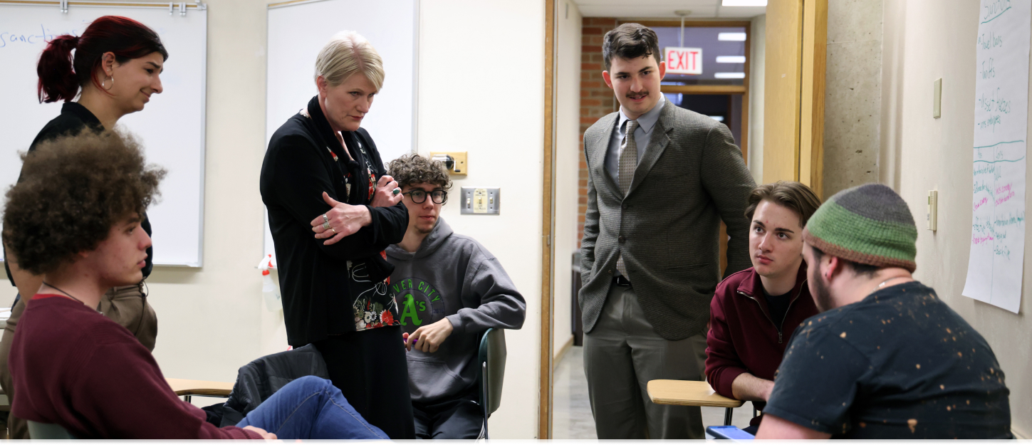Students having a discussion with their professor during class
