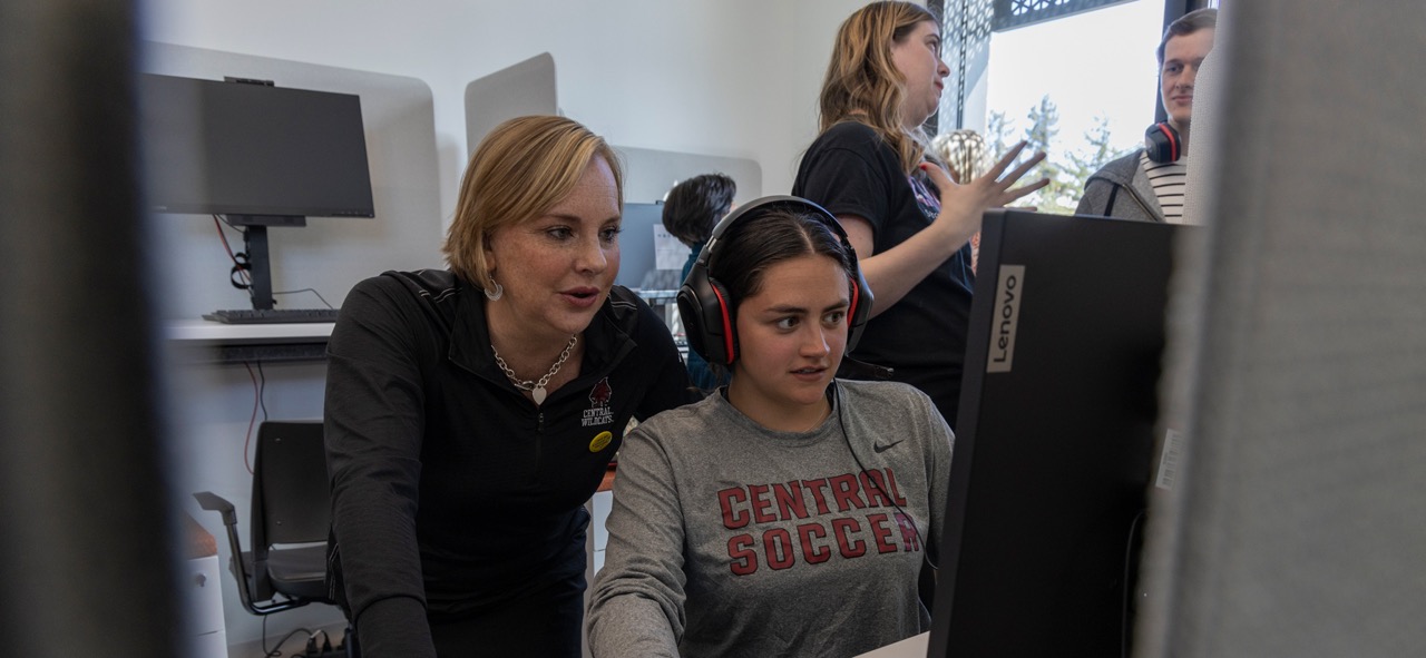 Professor working with student on a computer