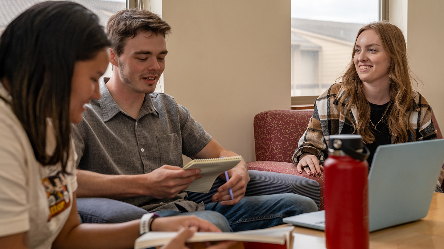 Three students talking outside of class. 