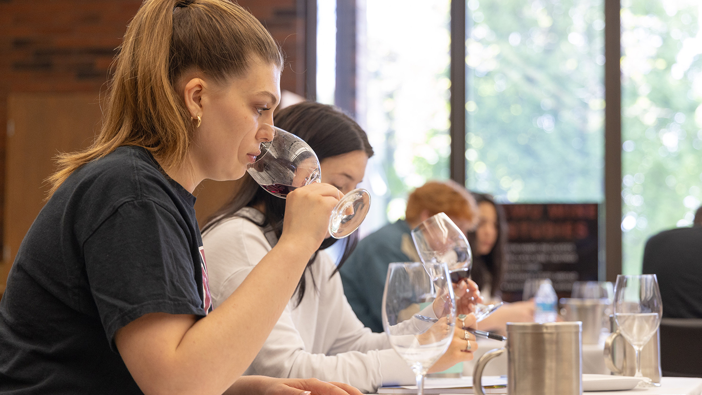 Student smelling wine during a tasting class.