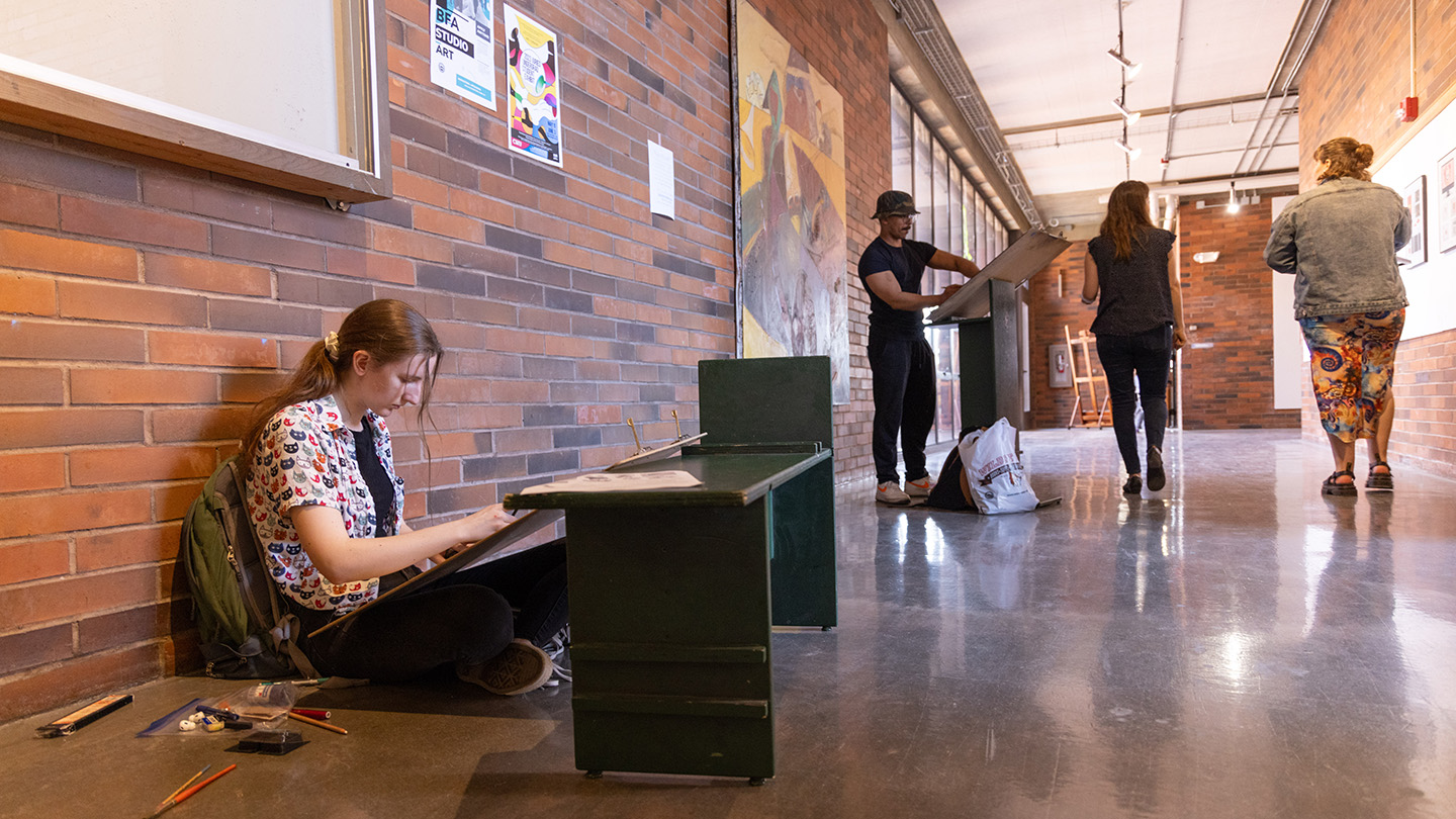 Students working on art projects in the hallway