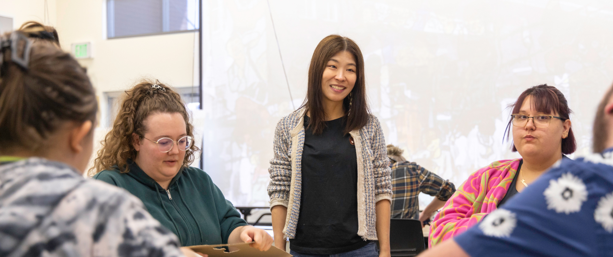Professor smiling at students during a presentation day