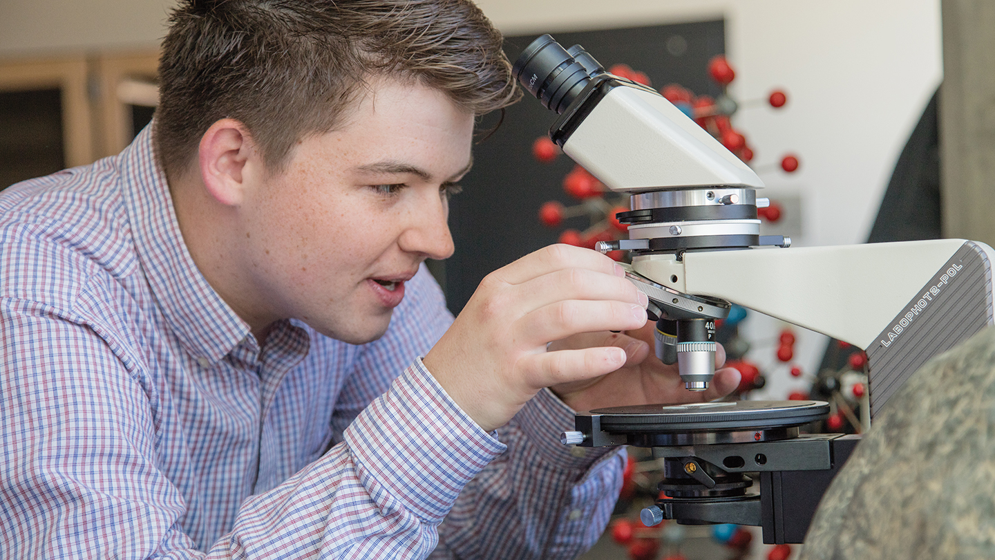 Student working in a lab with a microscope