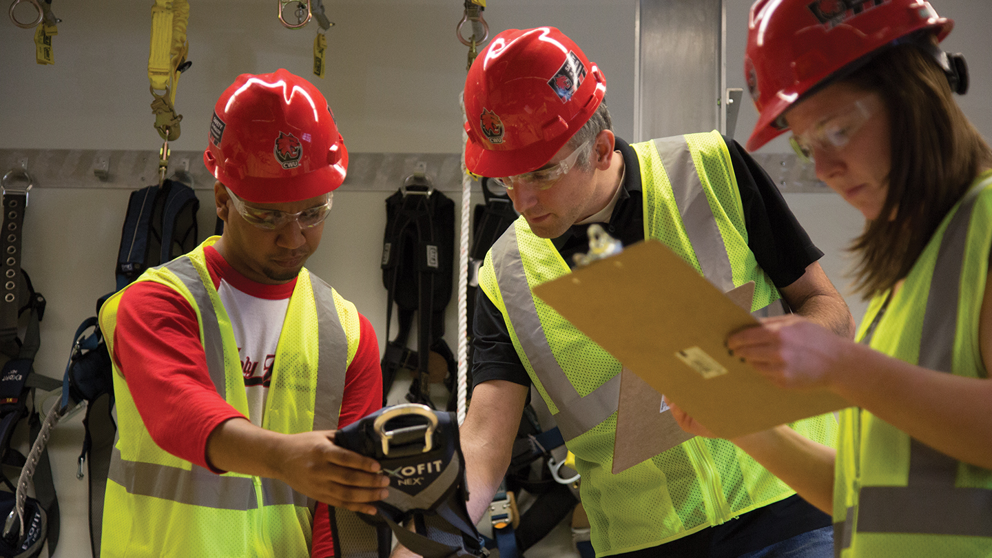 safety management students examining a harness