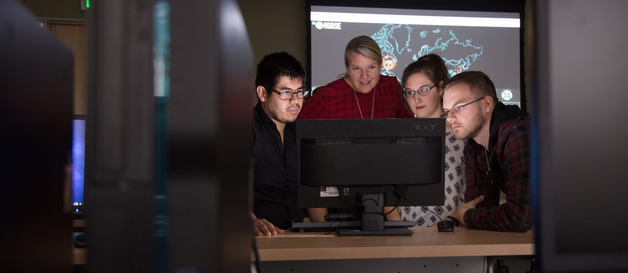 Students and professors looking at the computer