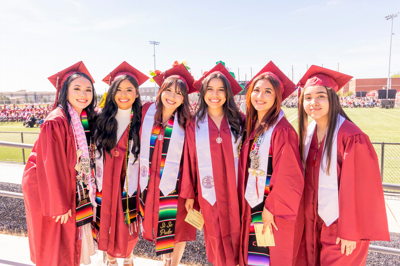 Graduates standing in their regalia smiling