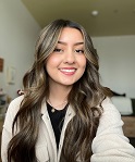 Elizabeth Escobedo smiling in a selfie. She is wearing a white cardigan