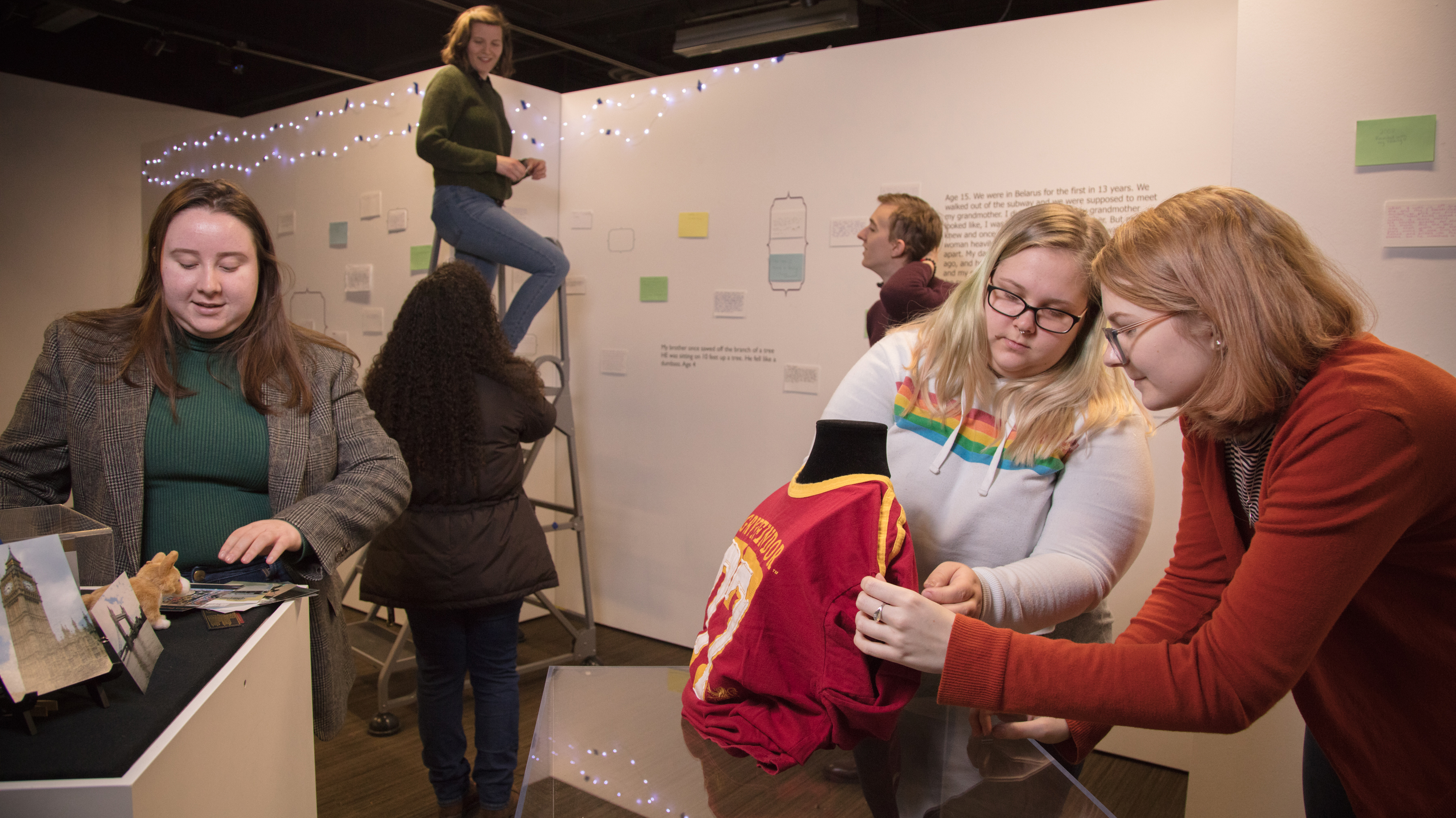 Several students work to install an exhibit. 