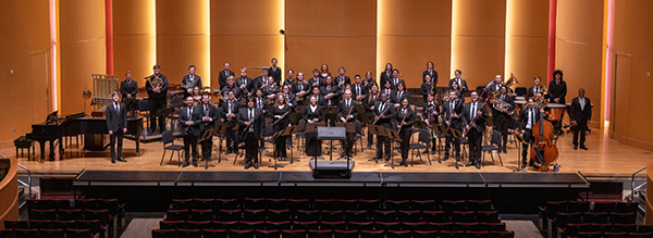 The CWU wind ensemble performance, centered in the stage is the conductor facing the audience.