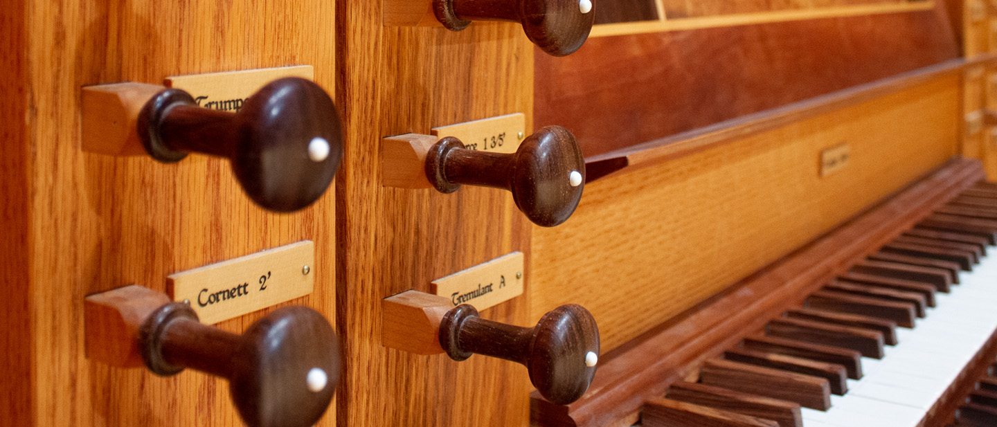 Closeup of pipe organ stops.