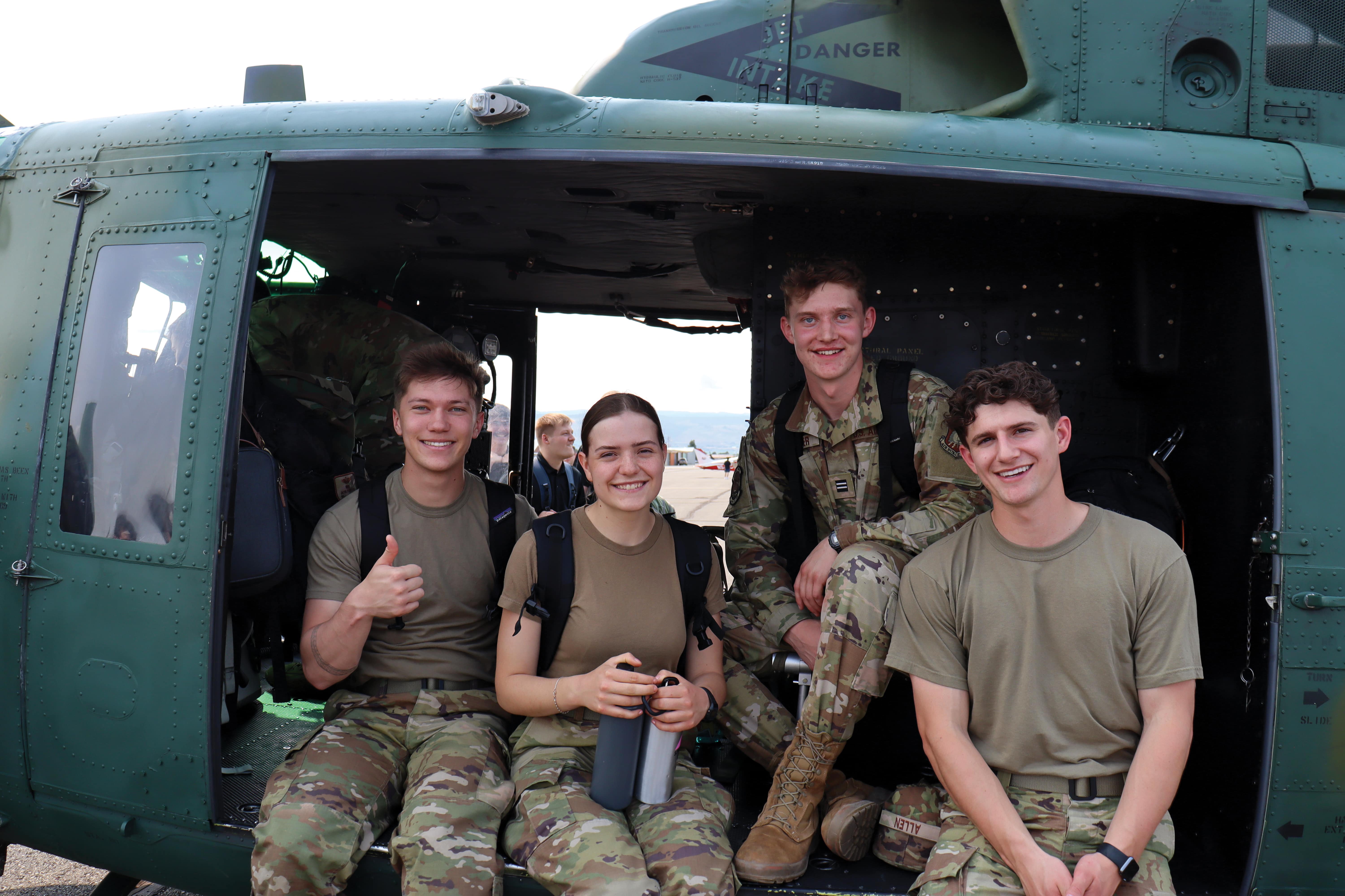 four students sitting in open-door helicoptor