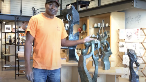Zimbabwean stone carver, Alexander Chitungo, stands next to his art work.