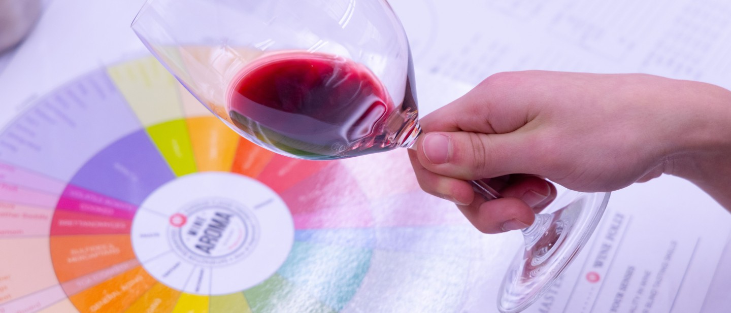 Glass of red wine over a color chart.