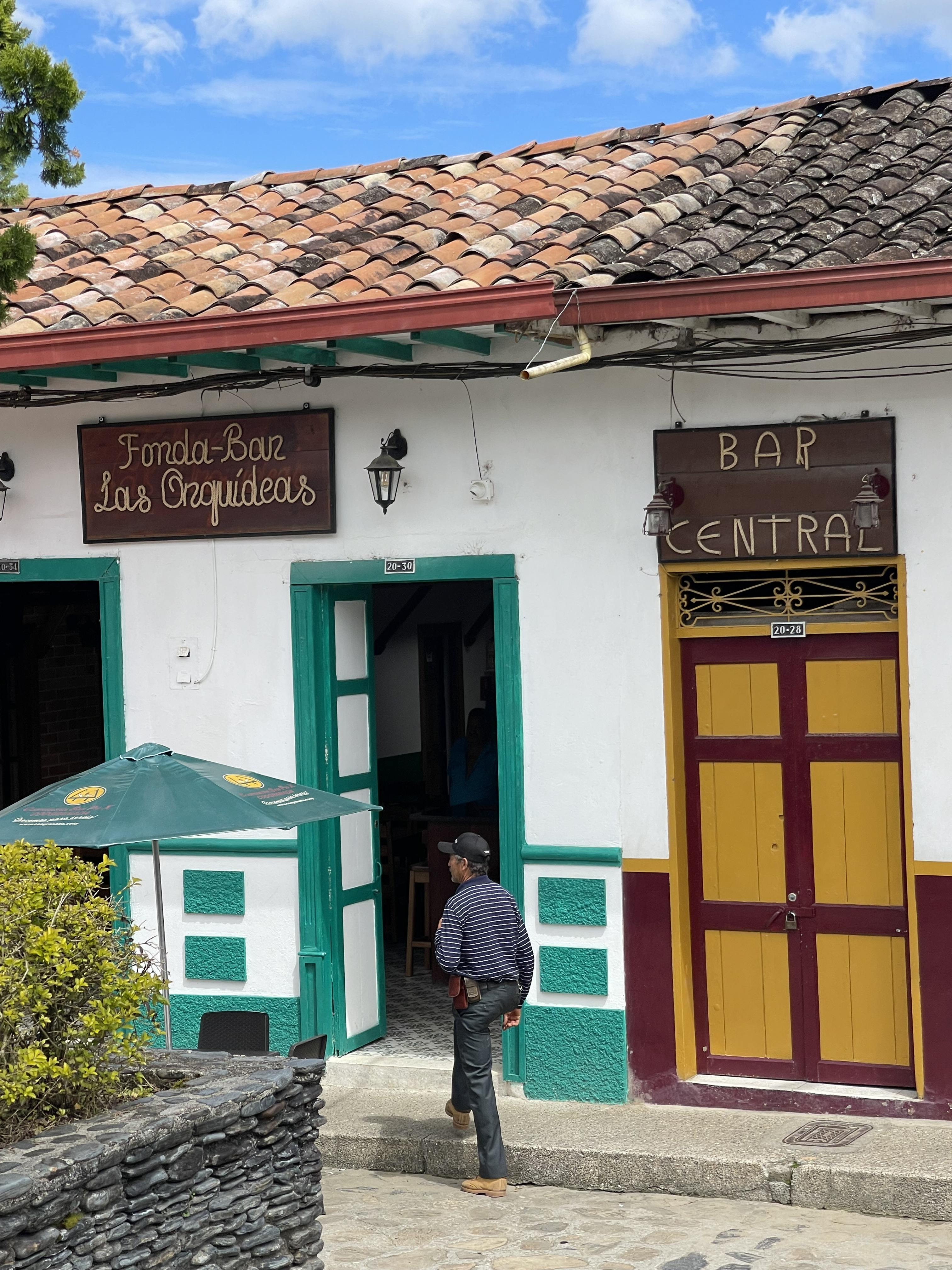 Outside of a colorful Building, a man is walking towards the entrance.