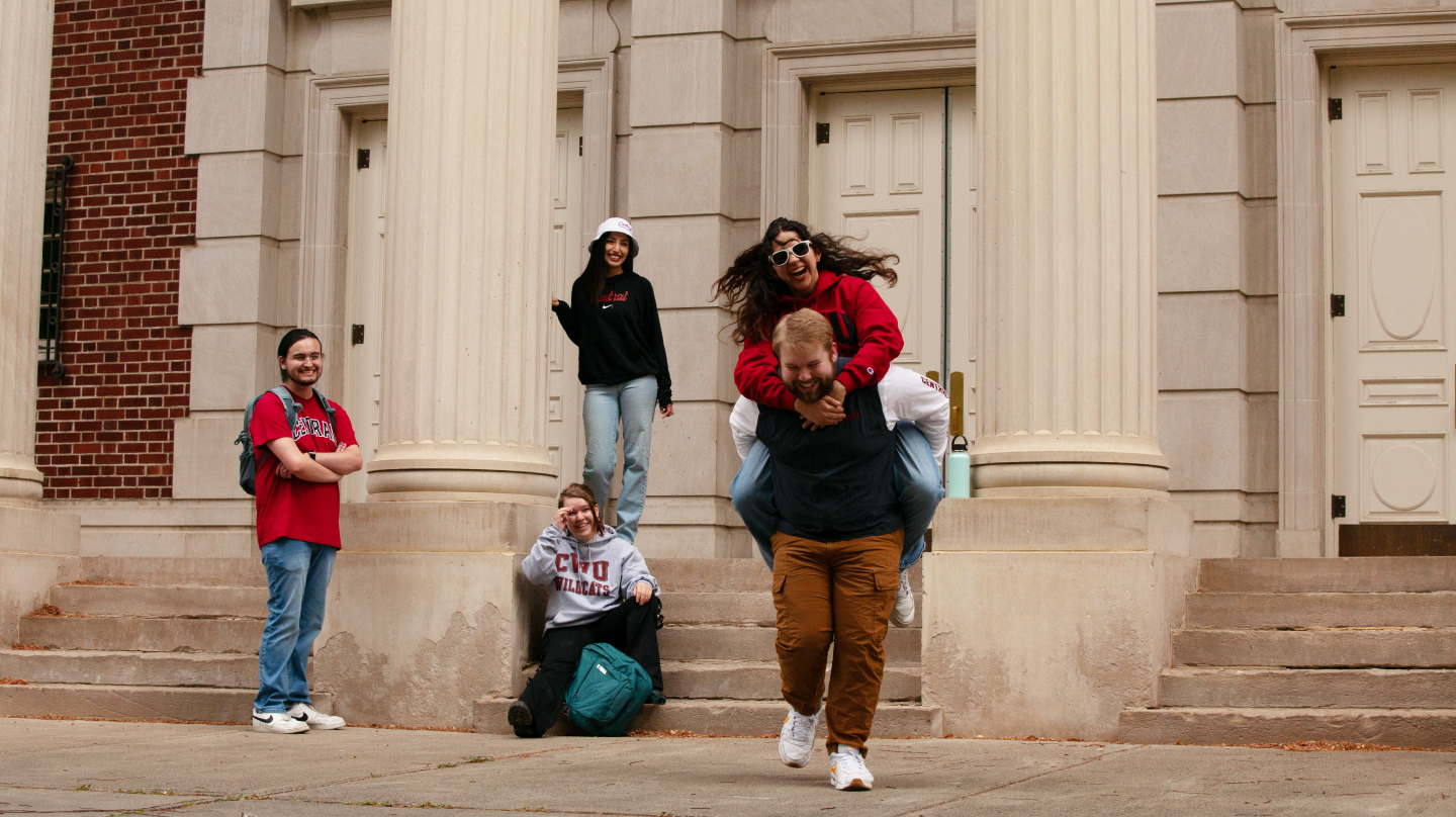 Students standing in front of a building excited for college