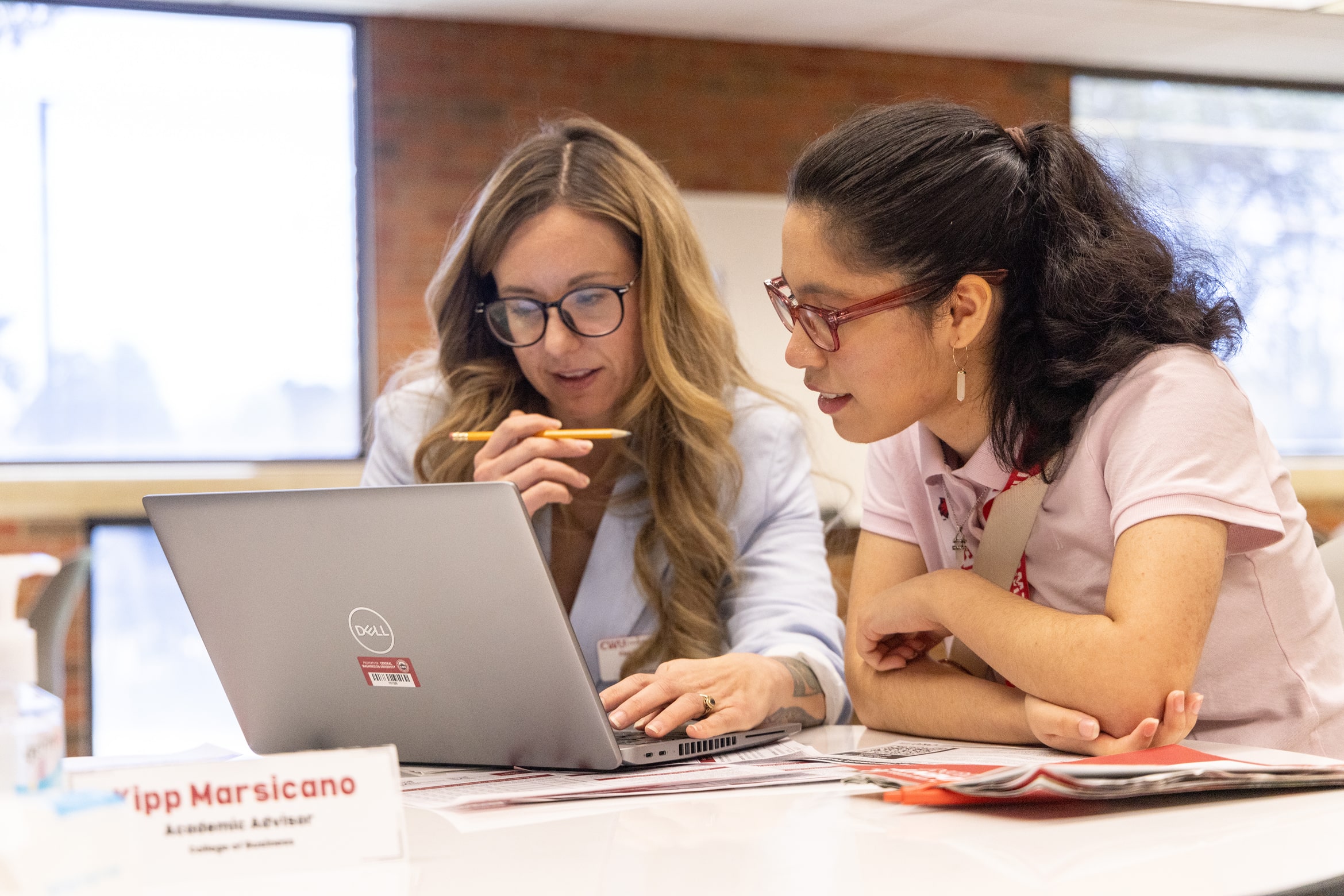 An Academic Advisor helps a student register for their Fall classes.